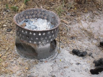 Fill the mbaula with charcoal bought from roadside, light (just like that of course) and swing to and fro by the handle to get it going, then put on ground and cook